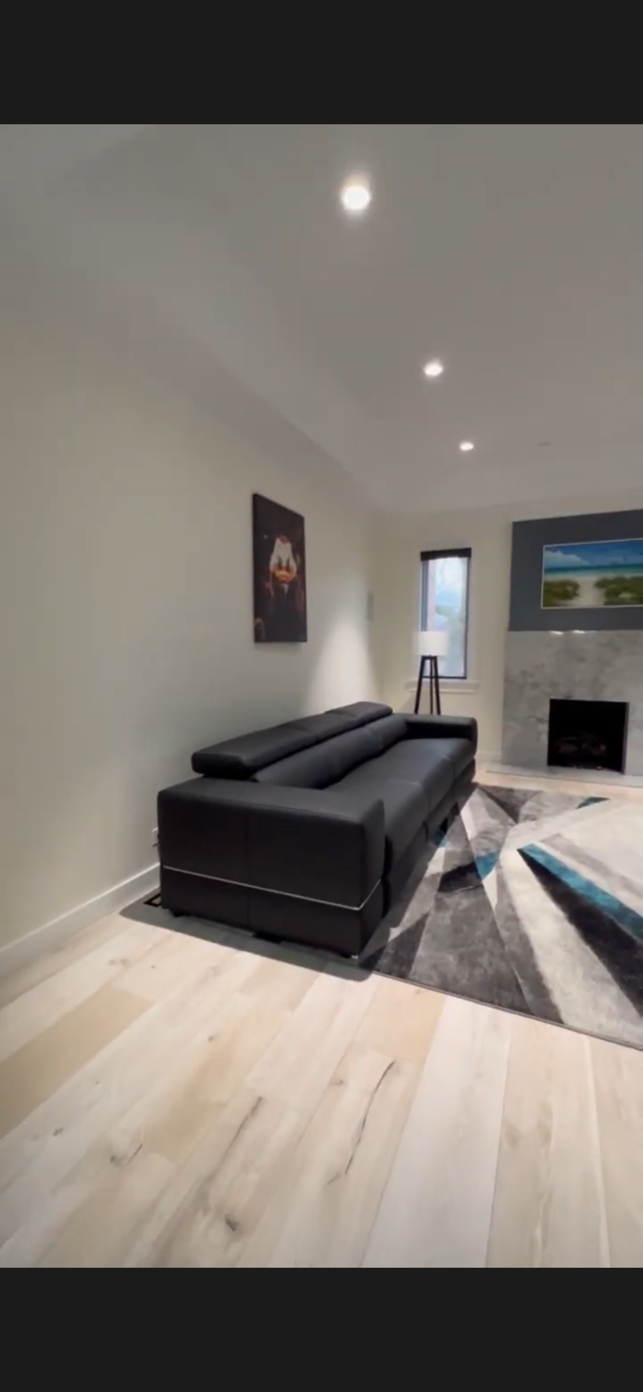 Living room with clean painted walls, fireplace accent, and wood flooring